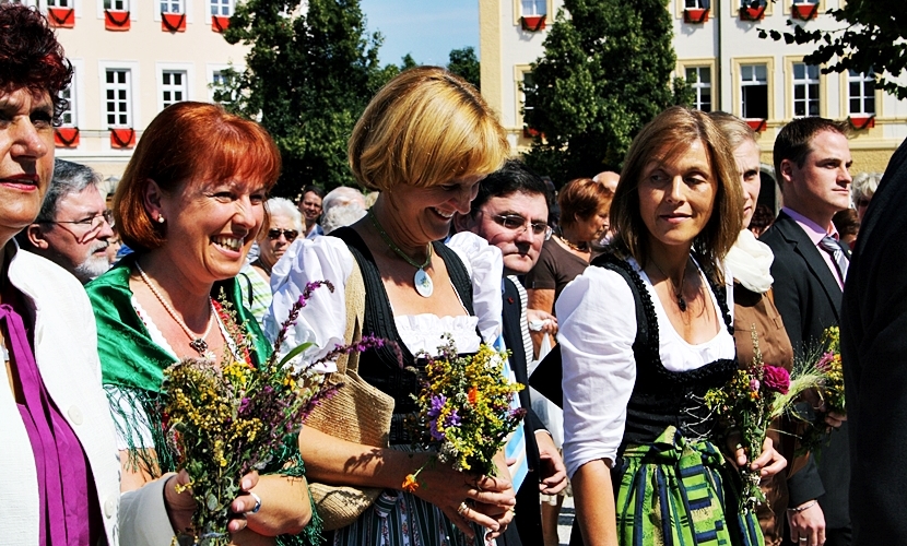 Damen im Dirndl und mit Blumenstäußen in Altötting.