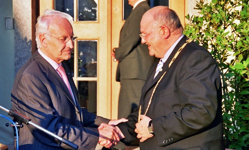 Ministerpräsident Stoiber schüttelt einem Herrn die Hand.