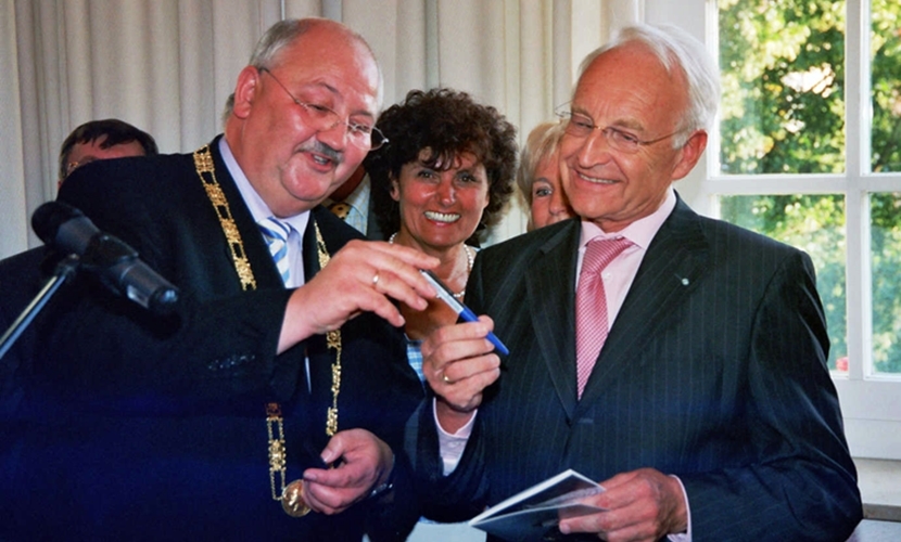 Bürgermeister Hofauer zeigt Ministerpräsident Stoiber einen Kugelschreiber.