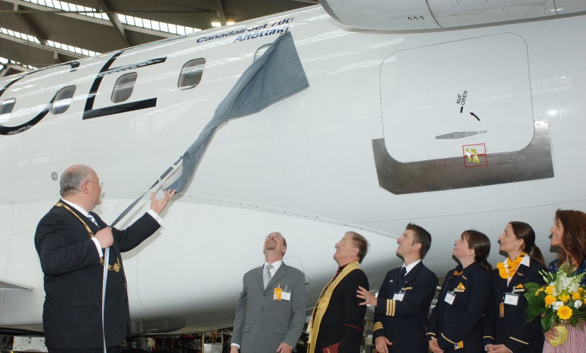 Bürgermeister Hofauer zieht ein Banner vom Schriftzug Altötting vom Flugzeug.