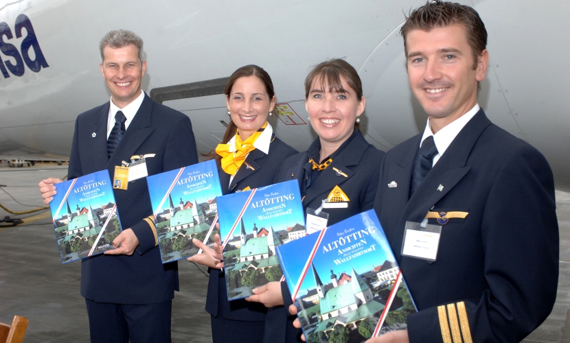 Mitarbeiter der Lufthansa halten den Altötting-Bildband hoch.