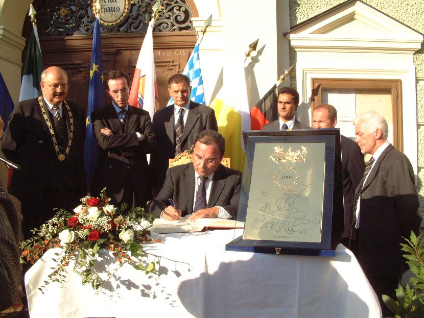 Bürgermeister Hofauer und weitere Ehrengäste stehen um die Ehrenplakette des Europarats. 
