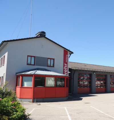 Gebäude der Feuerwehr Altötting mit parkenden Feuerwehrautos in der Garage.