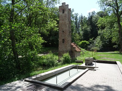 Das Kneippbecken mit dem Wasserturm im Hintergrund im Freibad Altötting. 