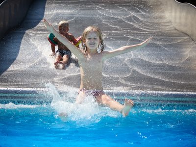 Kinder rutschen auf der Wellenrutsche im Freibad St. Altötting.