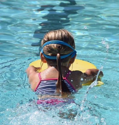 Hier ist ein junges Mädchen im Schwimmbecken.