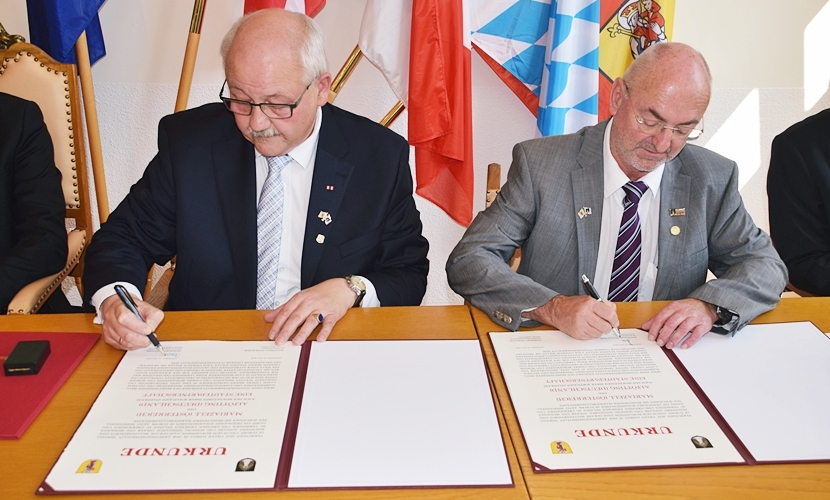 Die Bürgermeister von Altötting und Mariazell unterschreiben die Städtepartnerschaftsurkunde.