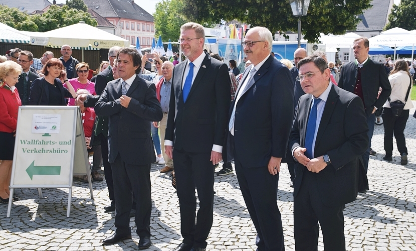 Vier Ehrengäste stehen vor dem Rathaus Altötting.