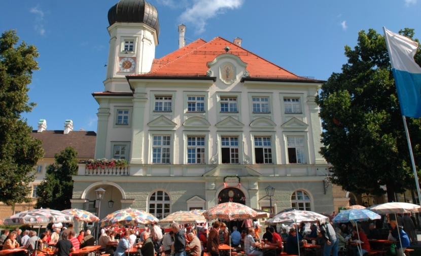 Besucher sitzen auf Bierbänken vor dem Rathaus.