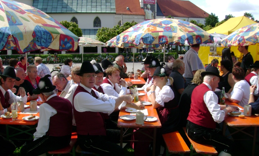 Gäste sitzen auf den Bierbänken vor dem Rathaus.