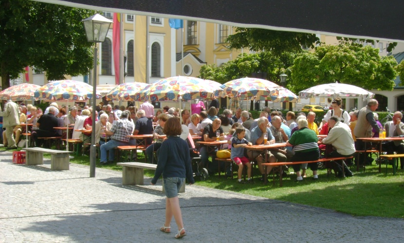 Gäste sitzen auf den Bierbänken vor dem Rathaus.