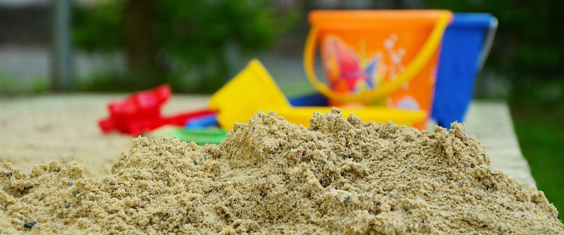 Detailaufnahme von einem Sandkasten mit Sandspielzeug
