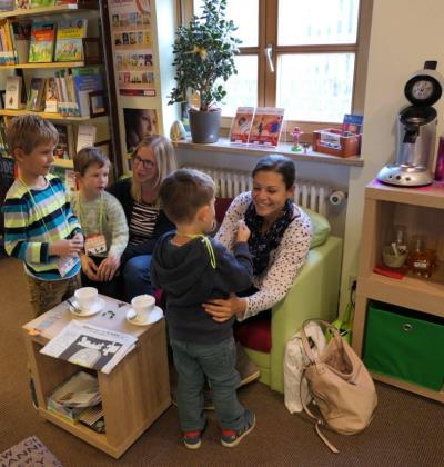 Stadtbücherei Altötting, Kaffee-Ecke im Elternbereich, Foto Stadt Zwei Mütter mit ihren Kinder in der Kaffee-Ecke im Erdgeschoss der Stadtbücherei Altötting im Elternbereich.