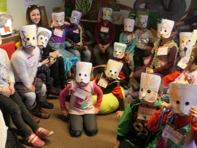 Kinder mit selbstgebastelten und bemalten Papiermasken bei der Vorlese3viertelstunde im Fasching in der Stadtbücherei Altötting.