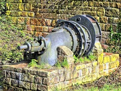 Ein altes Rohr vor einer alten Mauer.