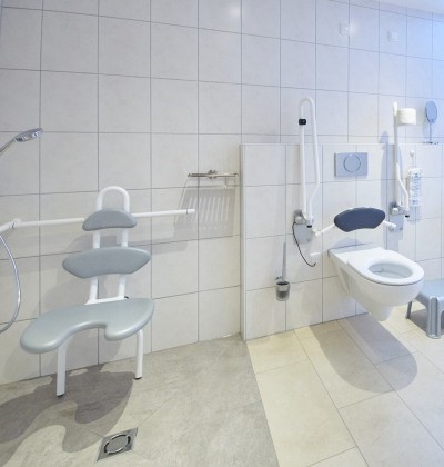 Behindertengerechtes Bad Altötting, Foto Stadel Hof Altötting Ein behindertengerechtes Bad, zu sehen ist links die ebenerdige Dusche mit Duschsitz und rechts das WC.