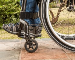 Räder eines Rollstuhls mit Rollstuhlfahrer auf ebener Fläche