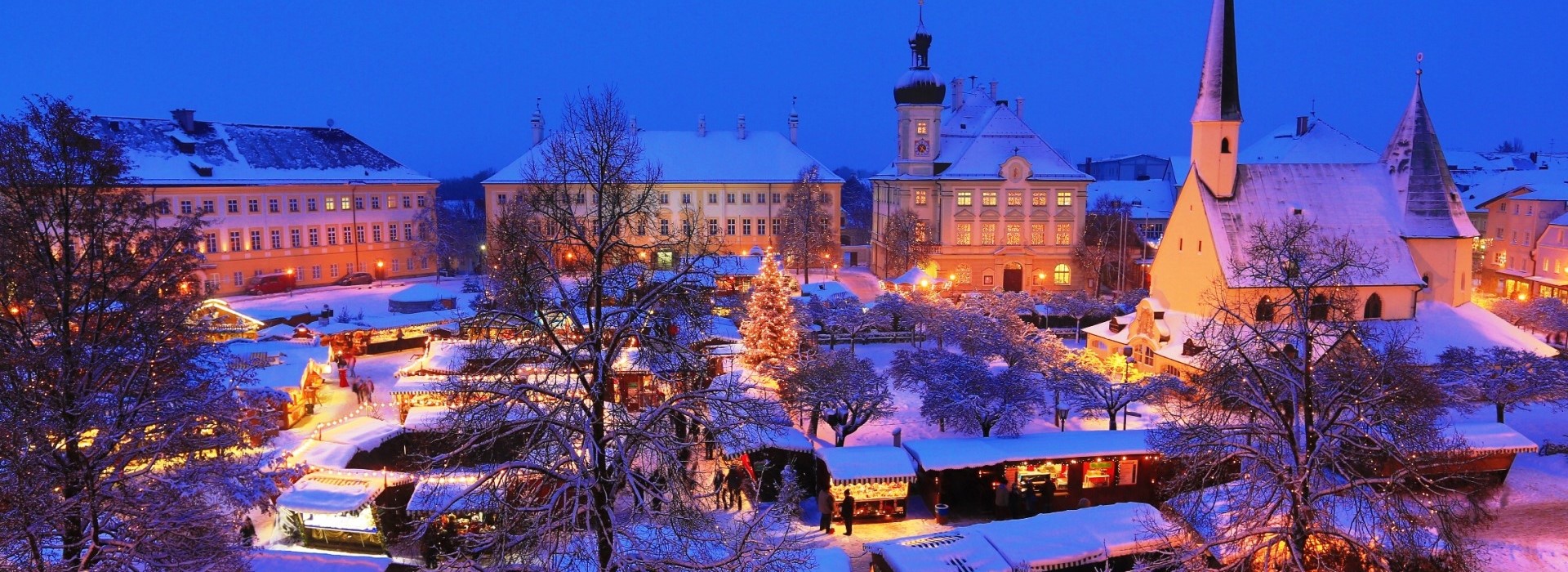 Der Altöttinger Christkindlmarkt auf dem barocken Kapellplatz mit Schnee.