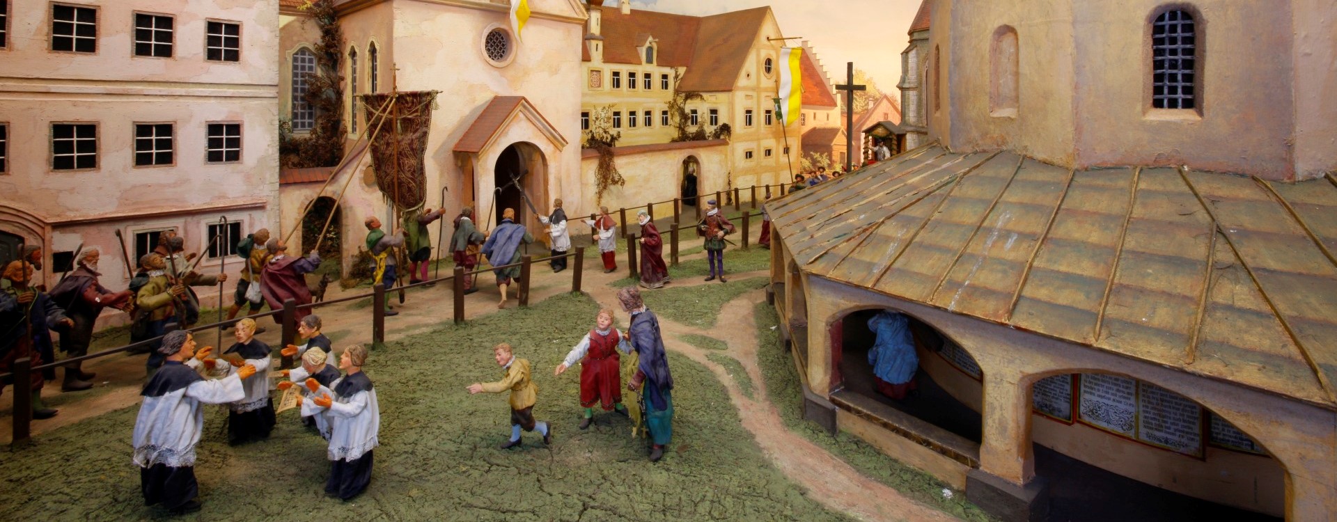 Ein Diorama der Dioramenschau Altötting, eine Pilgergruppe zieht in die Kirche ein.
