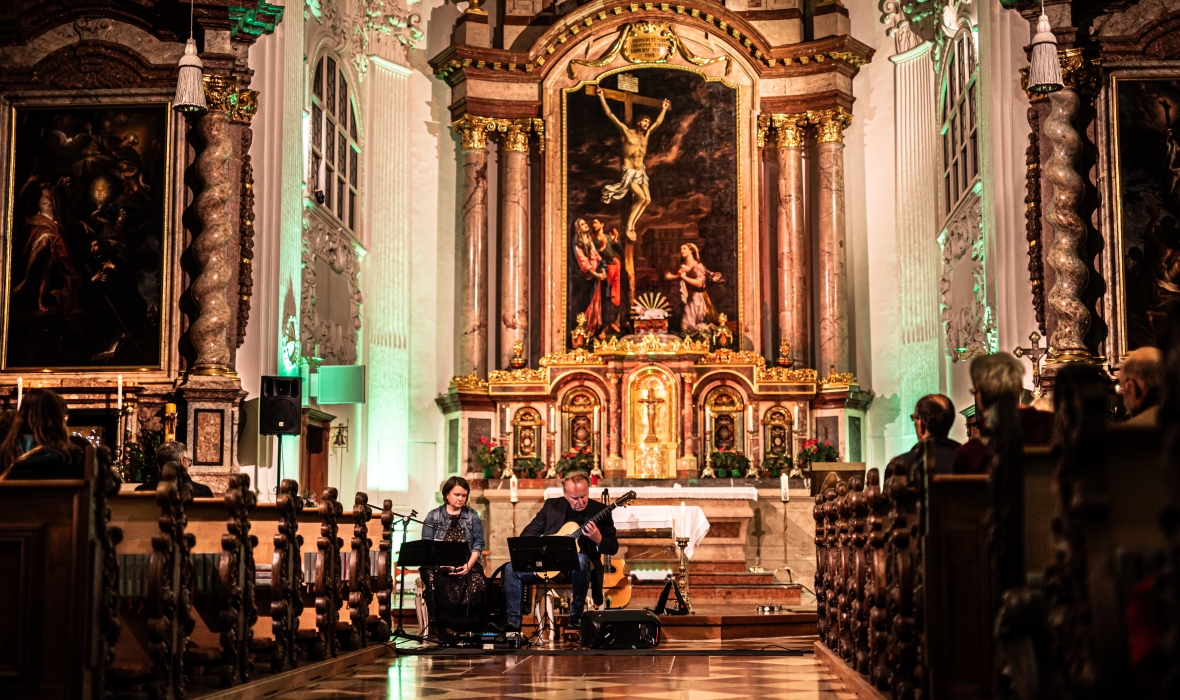In der St. Magdalena Kirche spielt ein Herr Gitarre und eine Dame singt