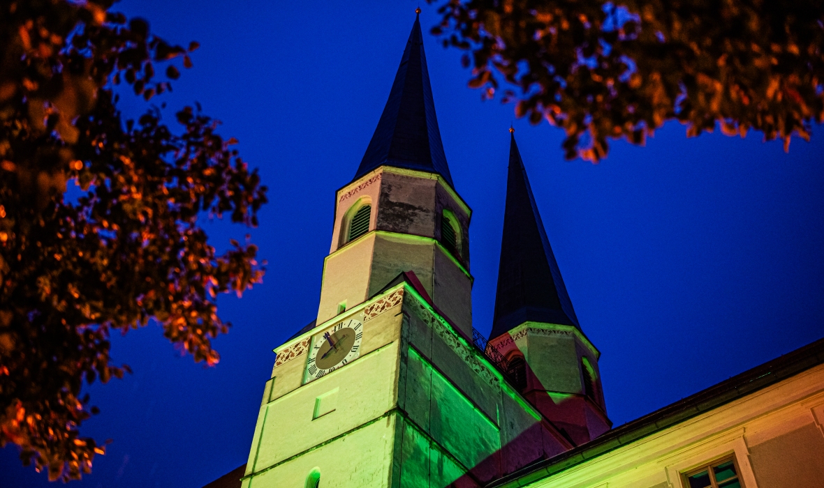 Außenblick auf die beleuchteten Türme der Stiftspfarrkirche.