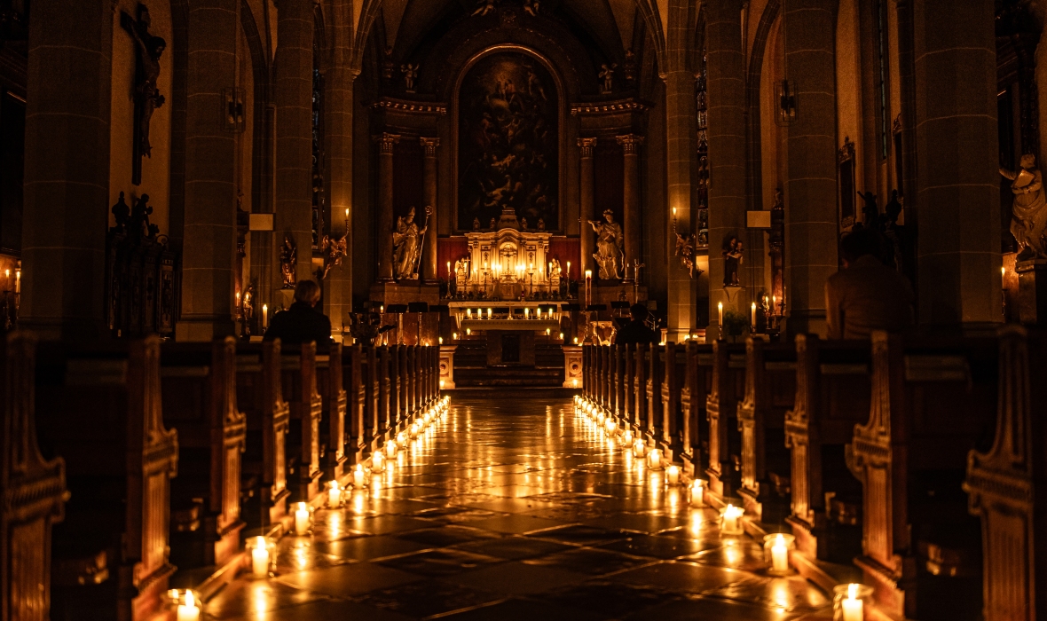 Die Stiftspfarrkirche ist nur mit Kerzen beleuchtet.