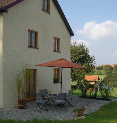 Außenansicht auf die Terrasse mit Garten der Ferienwohnung Klausen.