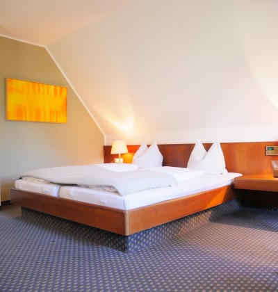 Blick auf ein Hotelzimmer mit Doppelbett.