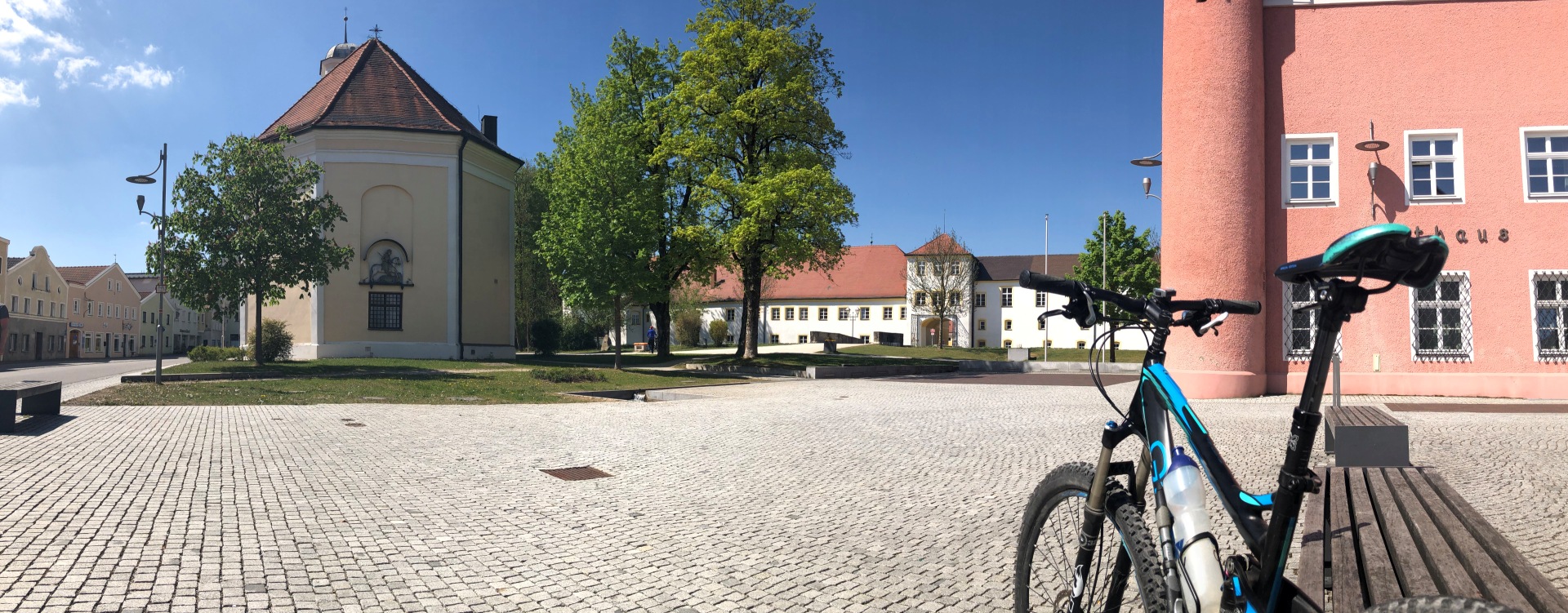 Hier sehen Sie den Stadtplatz in Tüssling mit einem Fahrrad im Vordergrund