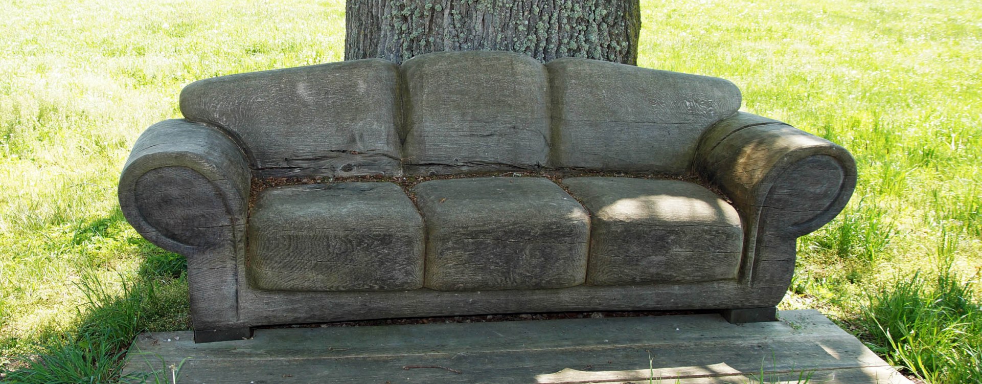 Holzsofa vor einem Baum in der Natur