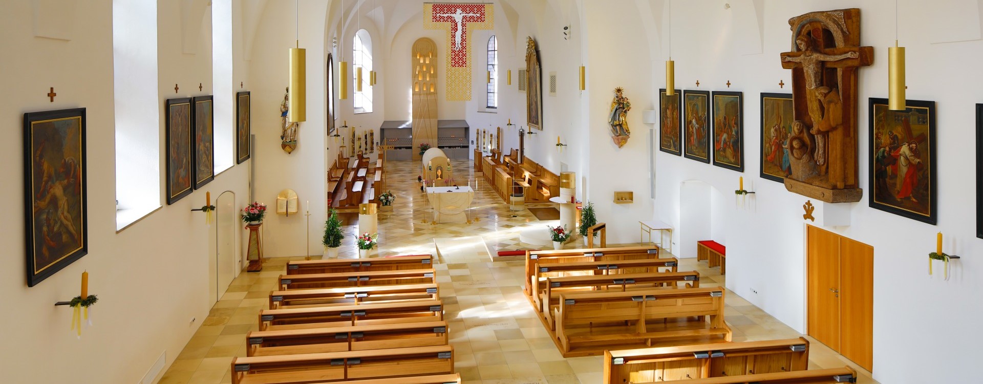 Innenaufnahme der Bruder Konrad Kirche mit Blick über die Bankreihen zum Altarbereich.