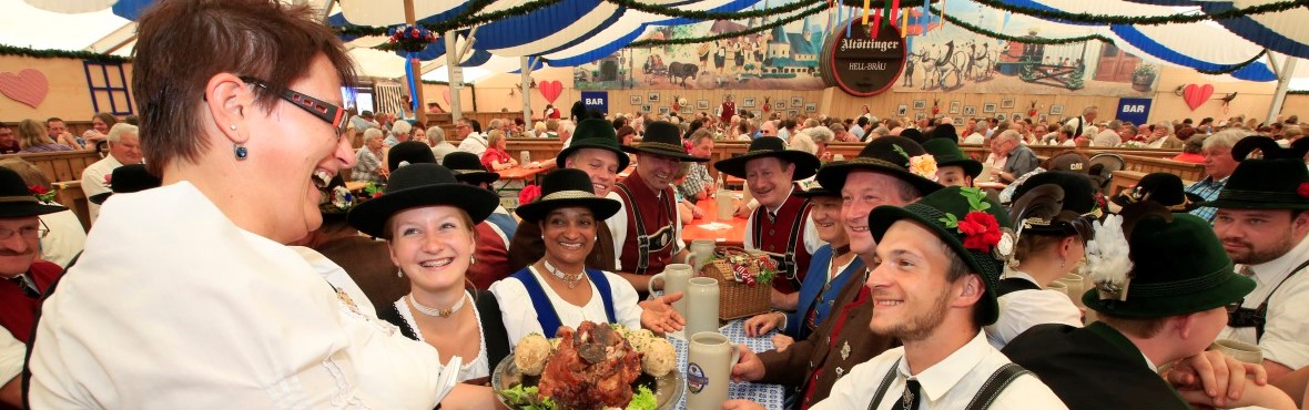 Einer Gruppe wird auf der Altöttinger Hofdult im Feszelt Essen gebracht.