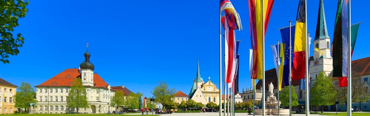 Der Altöttinger Kapellplatz mit den Fahnen im Vordergrund und dem Rathaus.