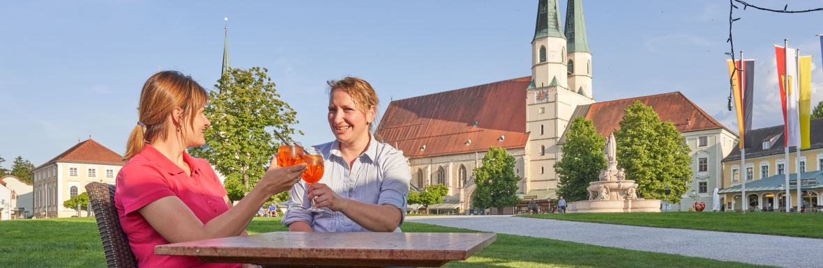 Sie sehen ein Café am Altöttinger Kapellplatz.