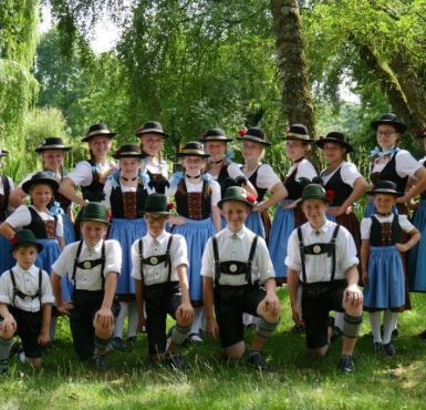 Jungen und Mädchen posieren in bayerischer Tracht. 