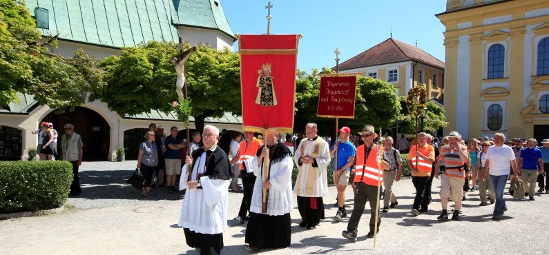 Eine Pilgergruppe zieht am Kapellplatz Altötting an der Gnadenkapelle vorbei, die Geistlichkeit führt den Einzug an.