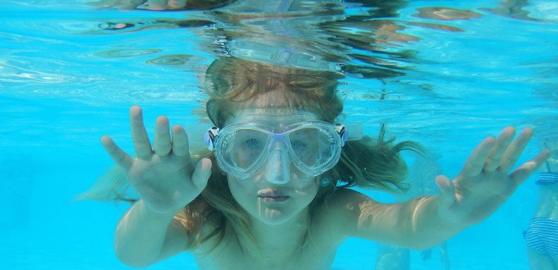 Hier sehen Sie ein Kind unter Wasser im Freibad in Altötting 