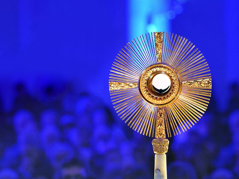 Nahaufnahme einer Monstranz auf blauem Hintergrund. 