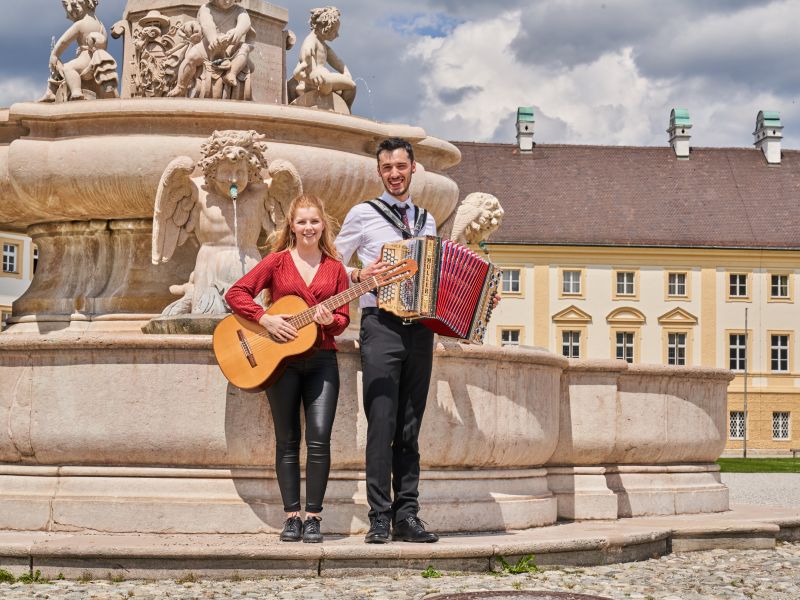 Hier sehen Sie zwei Musiker am Marienbrunnen in Altötting 