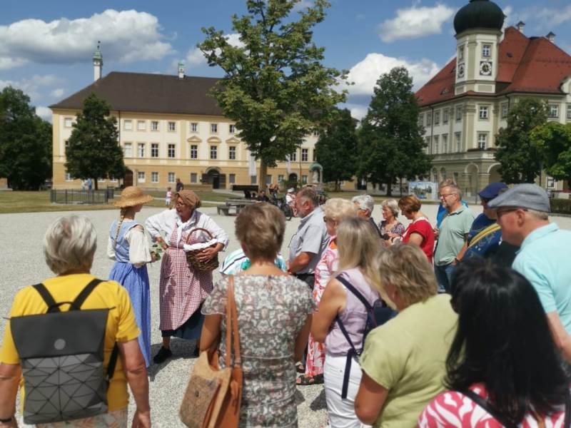 Zuschauer am Kapellplatz lauschen zwei Schauspielern.