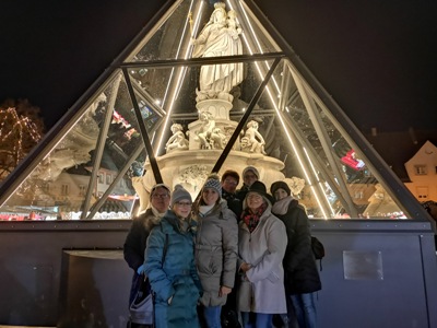Weihnachtsgrüße aus Altötting, Foto Tourismusbüro Altötting Das Team des Wallfahrts- und Tourismusbüros vor dem beleuchteten Marienbrunnen.