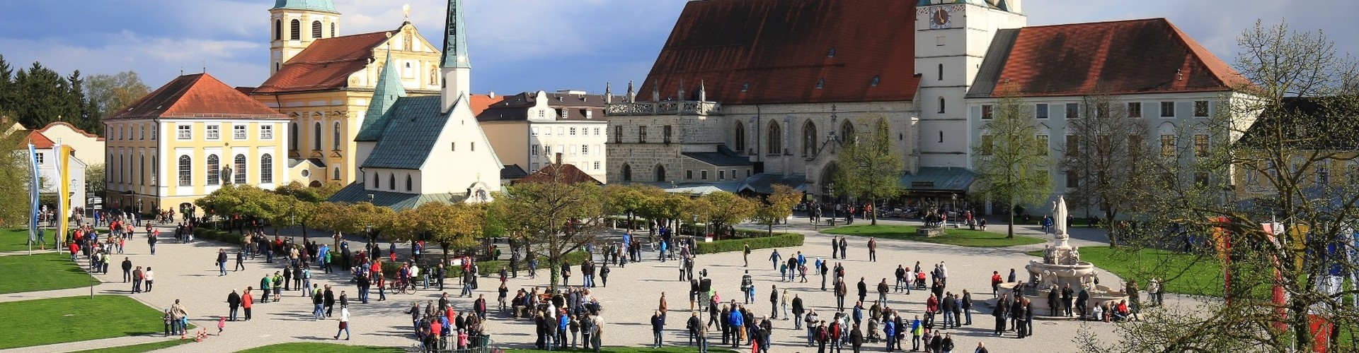 Ein Kapellplatzpanorama von Altötting mit einigen Pilgern.