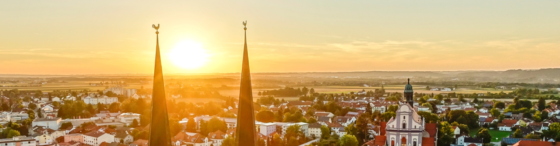 Hier sehen Sie einen Sonnenuntergang mit Stiftspfarrkirche 