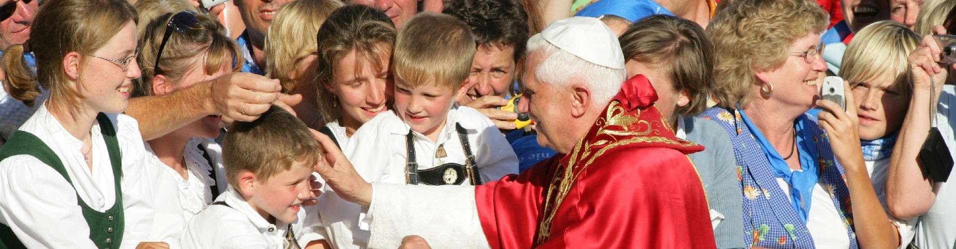 Ein Bild von Papst Benedikt, wie er in Altötting ein Kind segnet.