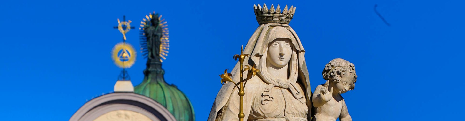 Statue einer Madonna auf blauem Himmel.