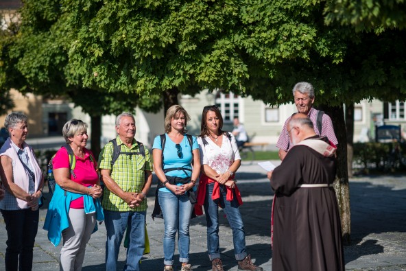 Eine kleine Pilgergruppe bekommt von einem geistlichen vor der Gnadenkapelle in Altötting einen Pilgersegen.