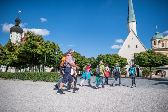 Eine kleine Pilgergruppe, die über den Altöttinger Kapellplatz zur Gnadenkapelle gehen.