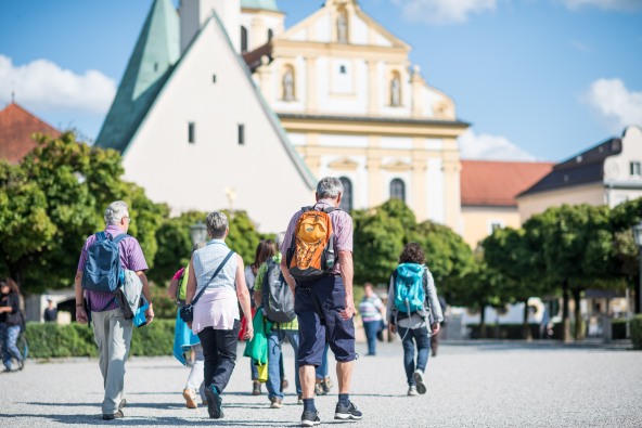 Eine kleine Pilgergruppe, die über den Altöttinger Kapellplatz zur Gnadenkapelle gehen.