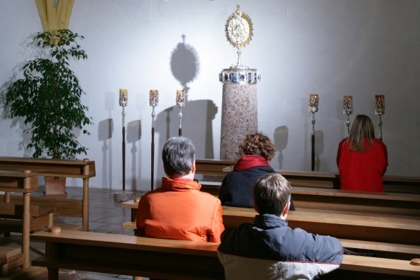 Ein paar Menschen beten in der Altöttinger Anbetungskapelle.