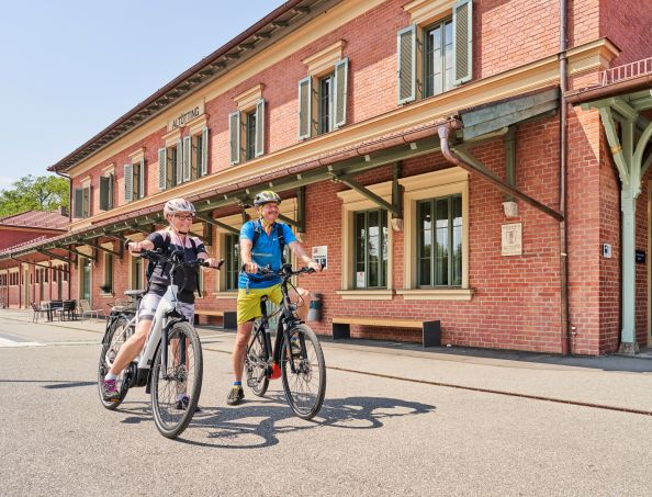 Hier sehen Sie zwei Fahrradfahrer am Altöttinger Bahnhof